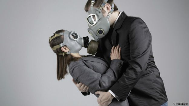 Мужчина и женщина обнимаются в противогазах